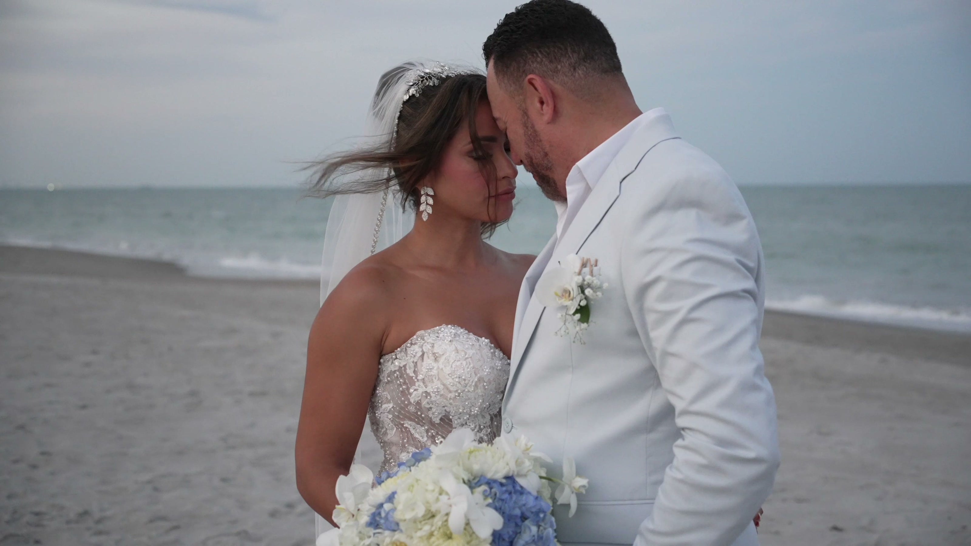 Newlyweds sharing a quiet moment beside the ocean